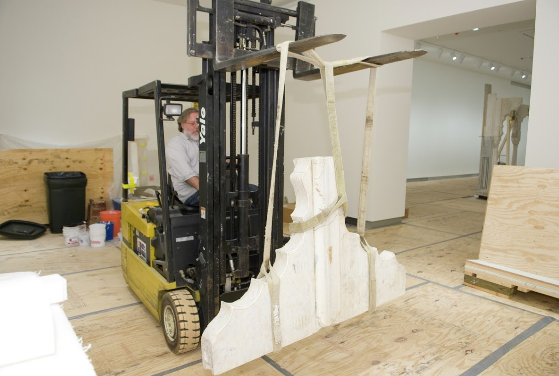 A conservator transporting a larger piece of the Garden Pavilion for conservation.