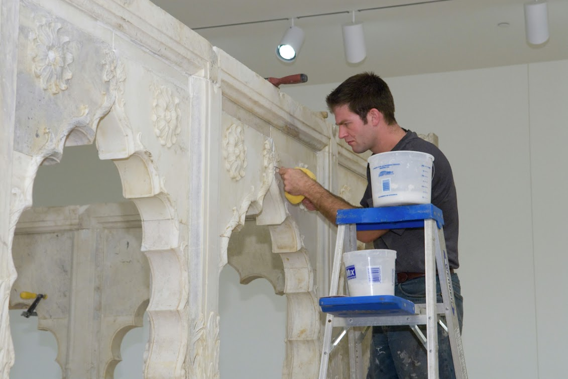 A picture of a conservator using adhesives to mend the pavilion preservation