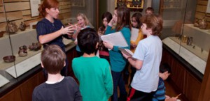 A group of children listen to an instructor in the galleries.