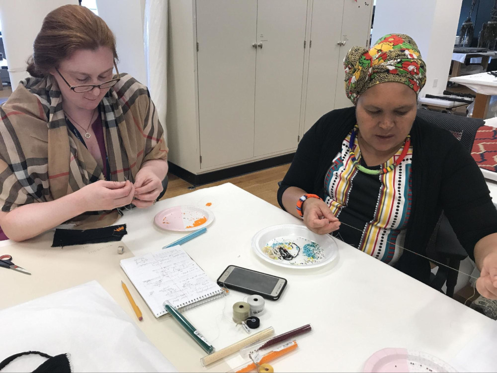 Kathryn Gabrielli (left) learns a traditional Zulu beading stitch from Hlengiwe Dube (right) in preparation for treatment. VMFA. June 15, 2017.