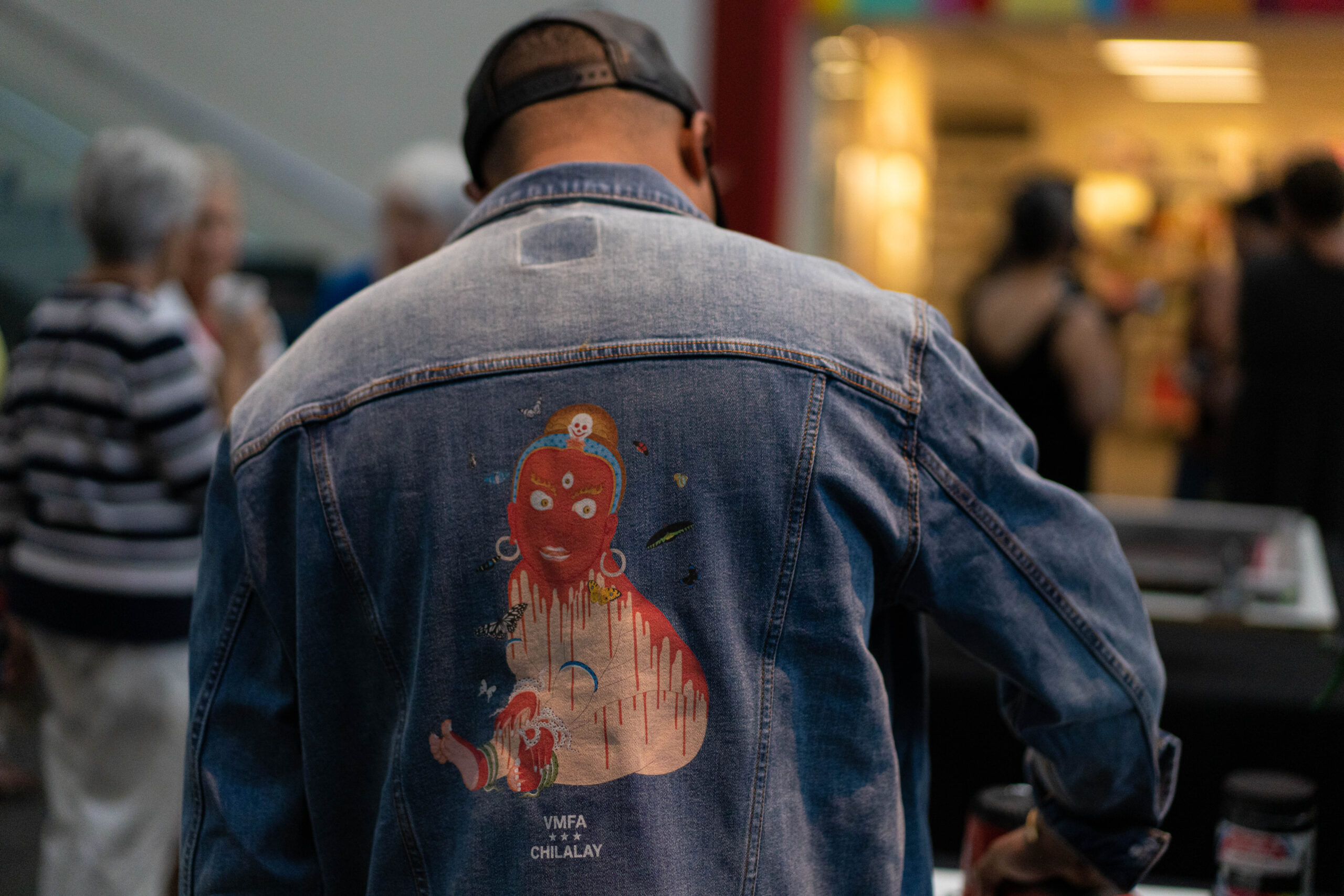 A man wears a denim jacket by Chilalay featuring art by Tsherin Sherpa. Photo by Al Feury, 2022