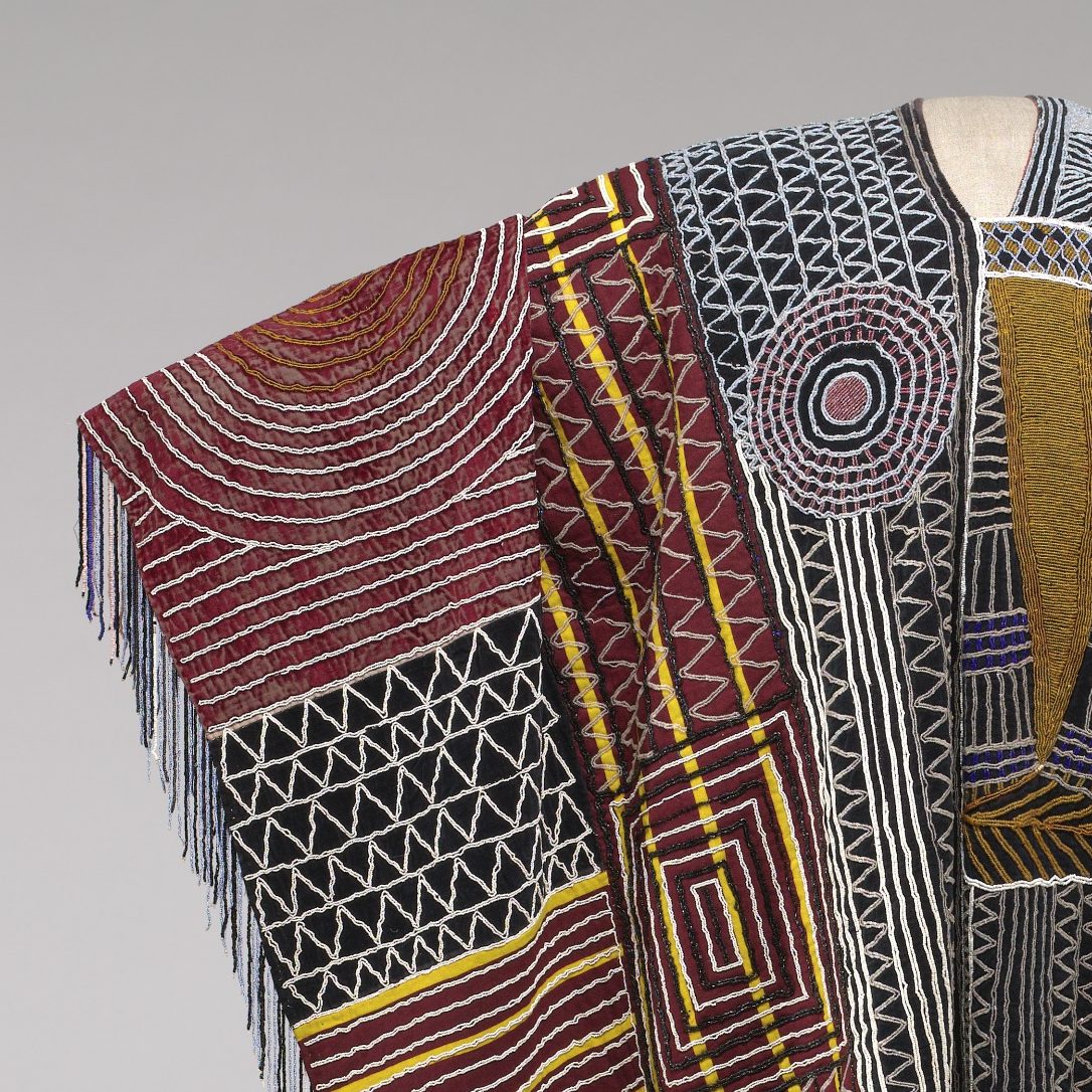 <p>In a nearby room in the African Art Gallery, look for the work of art that includes this detail. Who wore this colorful robe? Have you ever made a cape or robe using a piece of cloth? </p>
<p>How do folds and darts change flat cloth into clothing that can be worn by a person? </p>
