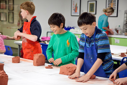 Kids work with clay in a studio class.