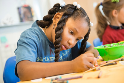 A girl draws during a studio class.